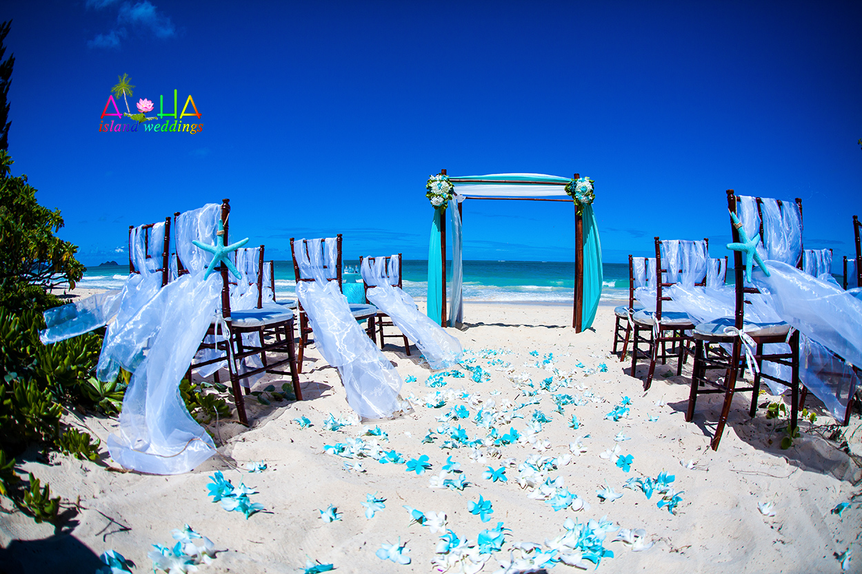 Turquoise and white beach setup with dark wooden chiavari chairs and a bamboo arch draped in white and blue